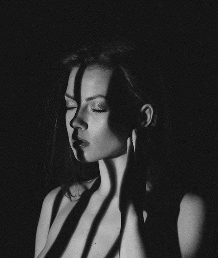 Striking black and white portrait with dramatic shadow effects, showcasing elegance and emotion.